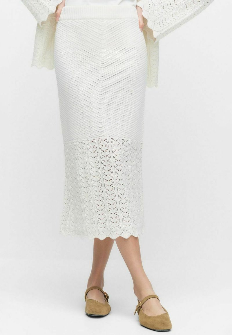 Jupe midi en tricot blanche avec un motif en chevron, un ourlet festonné et une partie inférieure texturée. Matériau doux avec une taille élastique ajustée.