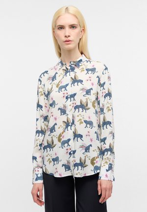 Button-up skjorte i cremet stof med et farverigt dyre- og blomstermotiv. Lange ærmer med knapmanchetter og klassisk krave.