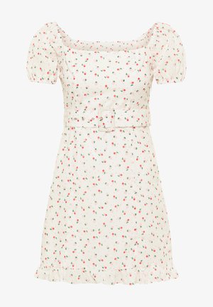 Robe blanche courte avec un décolleté carré, des manches bouffantes et une taille ceinturée. Présente un imprimé éparpillé de fraises et un ourlet à volants.