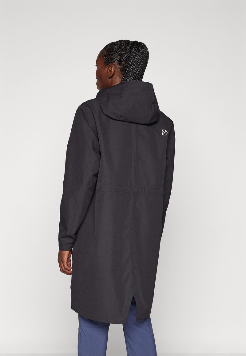 Langer schwarzer Regenmantel mit Kapuze, der an der Taille gerafft ist, seitliche Schlitze aufweist und ein kleines Logo auf dem Rücken hat. Glattes, wasserabweisendes Material.