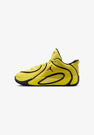 Zapatos deportivos amarillos con parte superior de malla, detalles en negro, detalles texturizados y diseño de corte bajo. Cuentan con suela de goma y sistema de cordones.