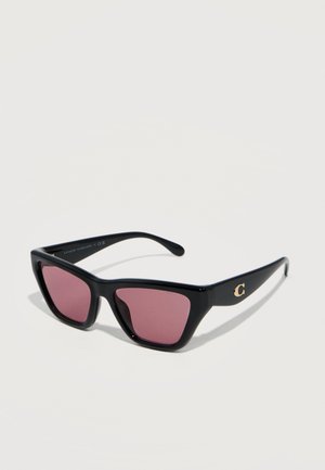 Black cat-eye sunglasses with pink lenses and a gold "C" logo on the temple, displayed on a neutral background.