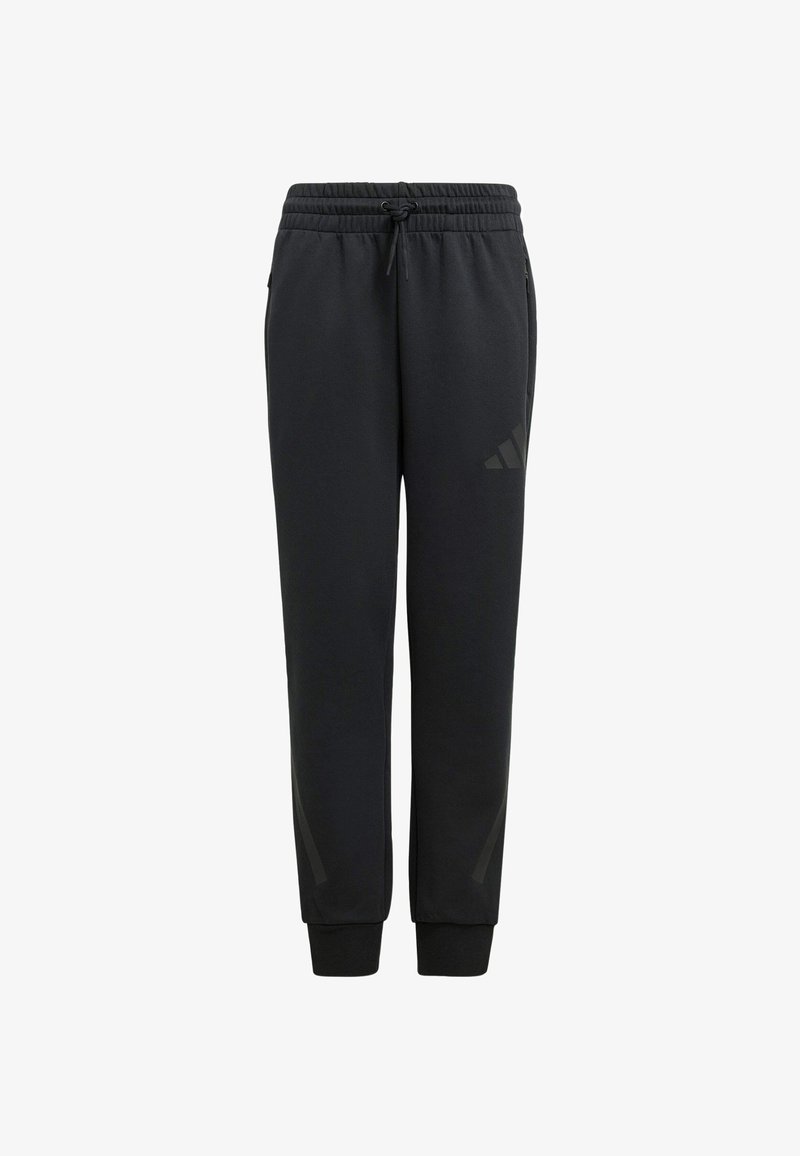 Melna sporta bikses ar aukliņu viduklī, sašaurinātiem ceļgaliem un smalku tonālu trīs svītru dizainu tuvu apakšējai kājai. Mīksta auduma tekstūra.