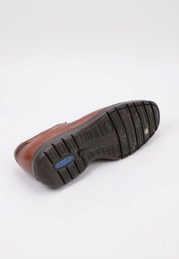 Brown leather shoe with a textured black rubber sole. Features a slight curve, embossed branding, and blue accent near the heel area.