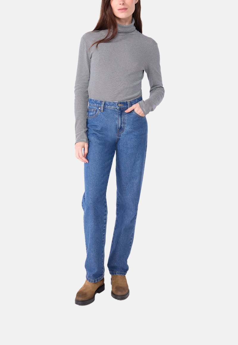 Grau gestreifte Langarm-Turtleneck-Bluse kombiniert mit hochgeschnittenen blauen Jeans und braunen Stiefeletten.