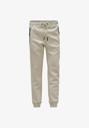 Pantalones de chándal color crema, ajustados, con cintura elástica, cordón, bolsillos laterales con cremallera y puños acanalados en los tobillos.