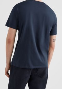 Camiseta de color azul marino con mangas cortas y cuello redondo, fabricada en un tejido suave. Presenta un diseño sencillo sin patrones ni acentos visibles.