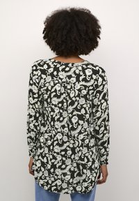 Blusa nera a maniche lunghe con motivo floreale bianco e azzurro chiaro, vestibilità rilassata, scollo rotondo e orlo curvo. Tessuto testurizzato.