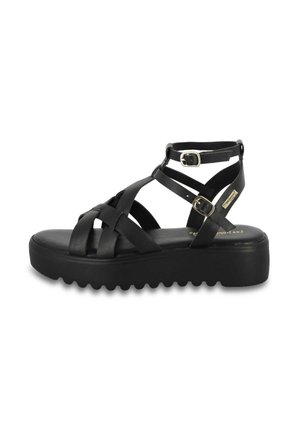Czarna sandałka na platformie z krzyżującymi się skórzanymi paskami, dwoma regulowanymi srebrnymi klamrami i żłobioną podeszwą.