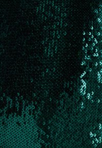 Grønt paliettestof med en blanding af mørke og lyse grønne nuancer, der har en glat, skinnende tekstur og en reflekterende overflade.