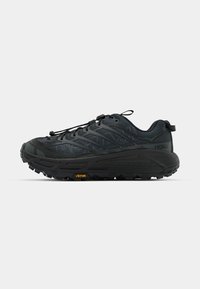 Juodos trailinių bėgimo bateliai su tekstūruota medžiaga, elastinga raištelių sistema ir Vibram padu. Yra atspindinčių akcentų ir palaikančios struktūros.