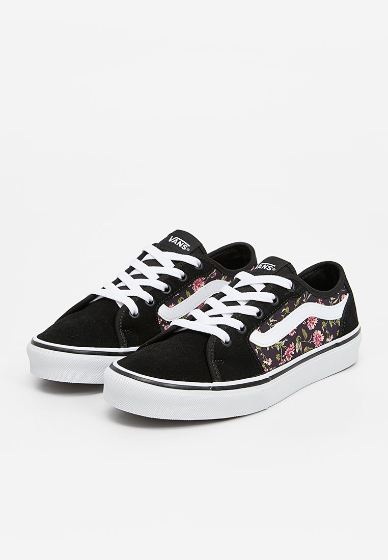 Baskets en daim noir avec lacets et accents blancs, présentant un motif floral sur le côté, bout rond et semelle en caoutchouc blanc.