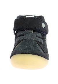Zapato azul de ante con suela de goma crema, que cuenta con una correa de Velcro y cordones grises. Acentuado con costuras blancas.