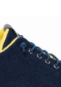Námořnické tenisky z filcu s žlutým vnitřním podšíváním, modré tkaničky a kovové očka. Zaoblená špička a polstrovaný jazyk pro pohodlí.