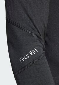 Sort langærmet stof med "COLD.RDY" branding; glat tekstur, tætsiddende pasform, med flade sømme langs armen for komfort og fleksibilitet.