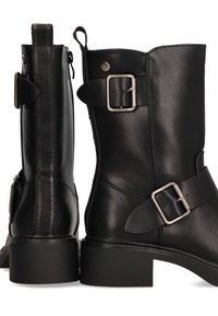 Botas de cuero negro hasta el tobillo con un diseño drapeado, acentos de hebilla plateada y un leve tacón. Presenta un detalle texturizado en el costado.