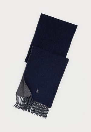 Écharpe en laine bleu marine avec un revers gris, extrémités frangées et petit logo brodé près d'un bord.