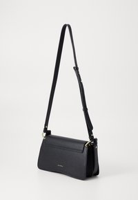 Black leather crossbody bag with a textured finish, adjustable strap, and gold hardware accents. Features a flap closure and structured shape.