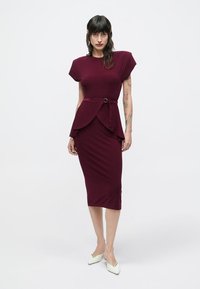 Obleka prilagojene oblike v barvi burgundca s kratkimi rokavi, pasom s pasnim detajlom in krilom do kolen. Gladek, raztegljiv material.