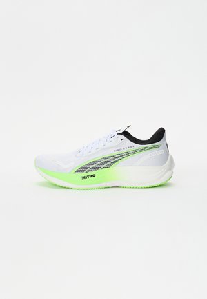 Zapatilla de running blanca con parte superior texturizada, acentos negros y suela verde neón. Presenta paneles de malla y el logo "NITRO" en el lateral.