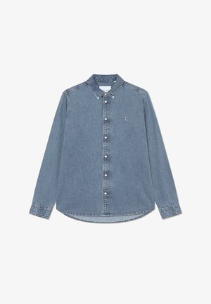 Chemise en jean à boutons de couleur bleu clair, avec un col pointu, des manches longues et un ourlet arrondi, ornée d'un discret logo sur la poitrine.