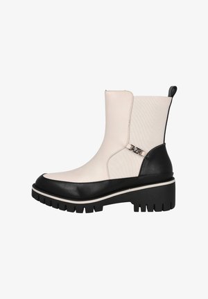 Botines en blanco y negro con suela gruesa, que presentan un acabado suave, colores contrastantes y un pequeño acento metálico cerca del tobillo.