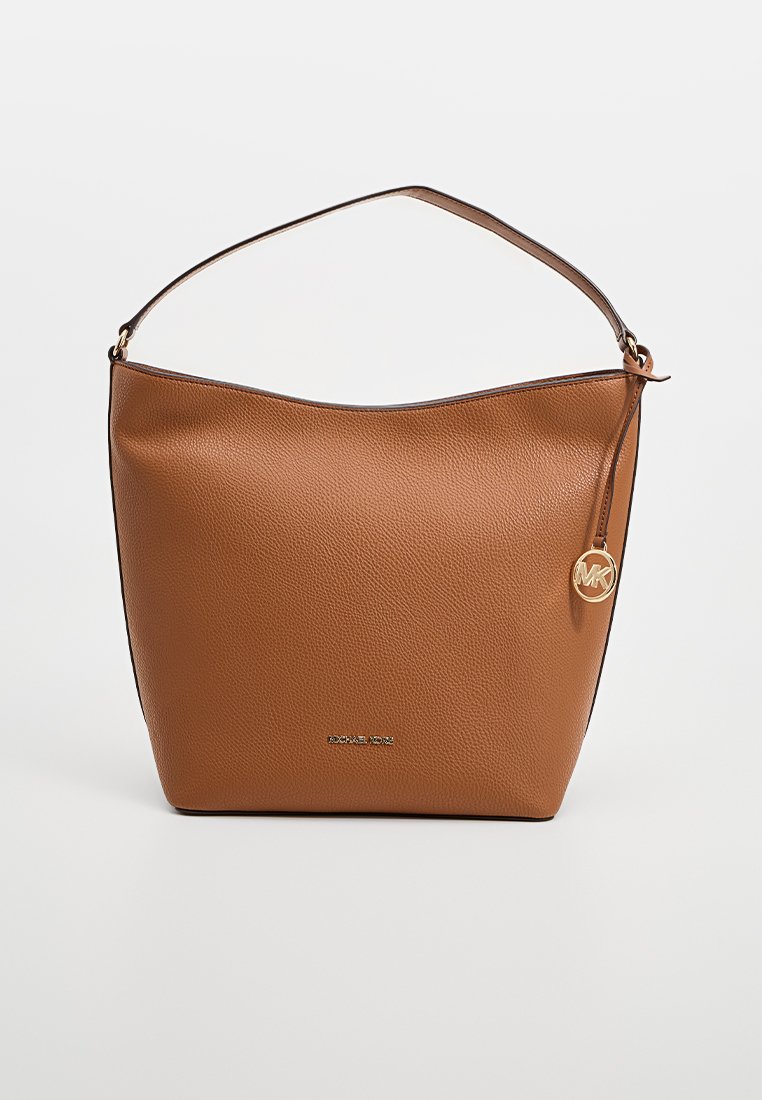 Bolso de hombro de cuero marrón con textura de guijarro, parte superior curva y detalles en dorado, que incluye un charm con logo circular.