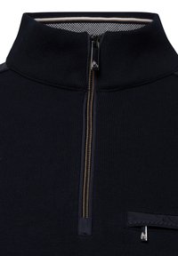 Marineblauer Half-Zip-Pullover aus strukturiertem Strickstoff. Verfügt über einen goldenen Reißverschluss und eine mit Reißverschluss verschlossene Brusttasche mit einem dunklen Akzent.