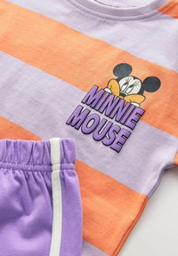 Violetti ja oranssi raidallinen T-paita, jossa on Minnie Mouse -grafiikka ja logo. Yhteensopivat violettiharmaat shortsit, joissa on joustava vyötärö ja valkoinen raita.