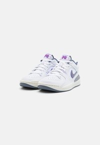 Weiße Sport-Sneaker mit lila Akzenten, ausgestattet mit einer perforierten Zehenbox, gepolstertem Kragen und Gummisohle. Logo und Branding auf der Zunge.