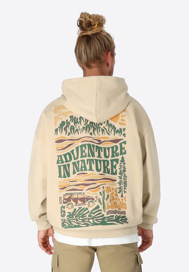 Beige Kapuzenpullover mit einem großen Grafikmotiv auf der Rückseite, das den Text "ABENTEUER IN DER NATUR" zeigt und Bäume, Wellen und ein Auto in erdigen Farben abbildet.