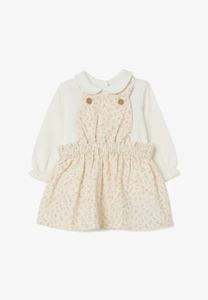 Robe pour bébé avec un haut blanc et une jupe à motif floral crème, avec un col et une taille élastique. Deux boutons décoratifs à l'avant.
