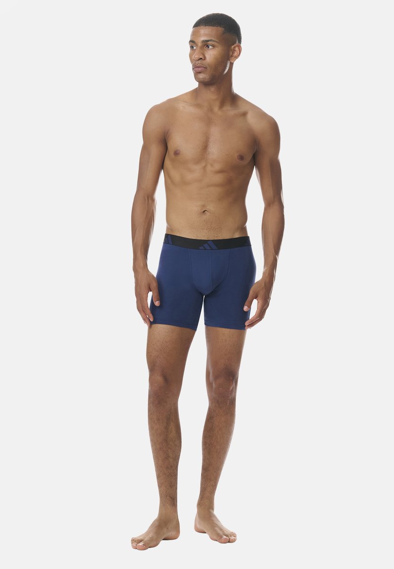 Boxers bleu marine en matériau doux avec une ceinture élastique noire arborant un logo discret et un design ajusté.