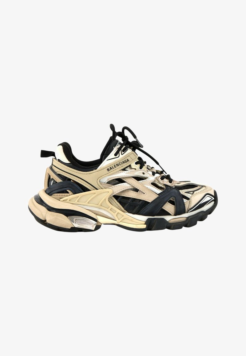 Baskets Balenciaga beige et noires épaisses avec un design complexe en couches et une semelle épaisse, avec lacets et logo sur le côté.