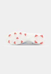 Sport shoe outsole in white with pink traction spikes. Textured surface with grooves for grip. Design features a blend of materials and colors.