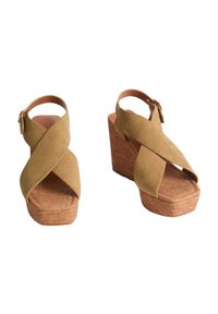 Sandali wedge in suede con design a fascetta incrociata, colore beige, piattaforma in sughero e cinturino alla caviglia con dettaglio della fibbia.
