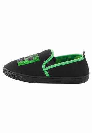 Sort slip-on sko med grøn kant, grøn pixeleret indre, sort sål og grøn paliet firkantet dekoration på toppen.