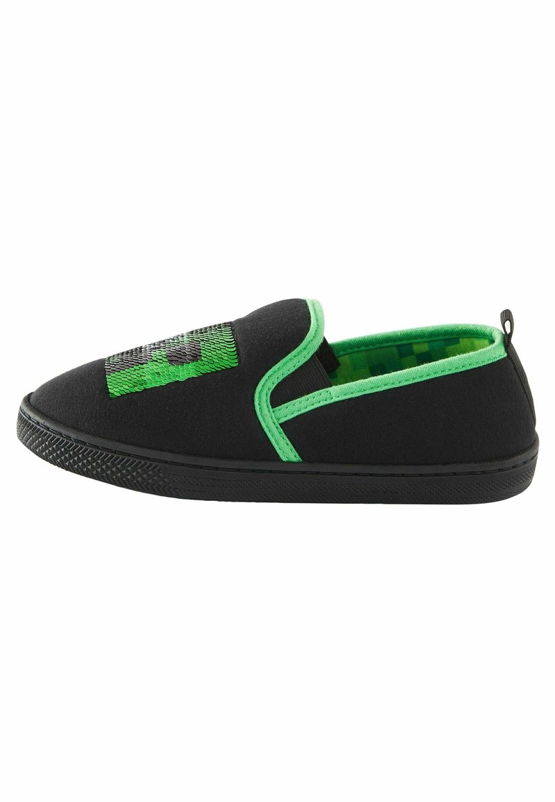 Chaussure noire à enfiler avec une bordure verte, intérieur pixelisé vert, semelle noire et décoration carrée en sequins verts sur le dessus.