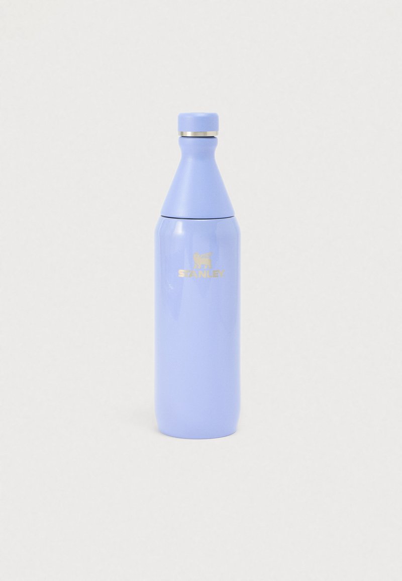 Šviesiai violetinė Stanley izoliuota vandens buteliukas su sidabriniu žiedu prie sriegio dangtelio, ant paprasto balto fono.