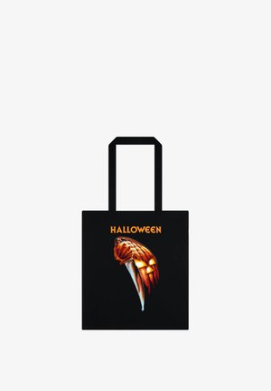 Black tote bag featuring a graphic of a pumpkin with a knife, and the text "HALLOWEEN" in orange above the design.
