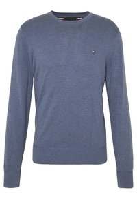 Maglione blu lavorato a maglia con scollo rotondo, maniche lunghe e un piccolo dettaglio del logo sul petto. Texture morbida e polsini a coste.