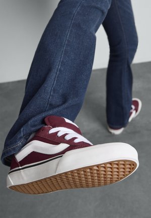 Maroon canvas sneaker with white accents and laces, featuring a rubber sole with a diamond pattern and contrasting black stripe.