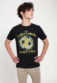 Černé bavlněné tričko se žluto-modrým grafickým motivem blesku a fotbalového míče s textem "OFICIÁLNÍ LIGHT'N'ING QUICK PRO."