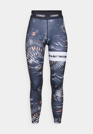 Leggings de cintura alta feitos de tecido elástico, apresentando um padrão abstrato escuro com acentos coloridos e riscas horizontais brancas.