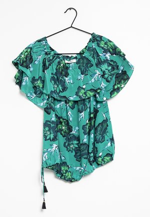 Blusa verde a fantasia floreale con maniche a volant, collo elasticizzato e orlo con coulisse e pon pon. Realizzata in tessuto leggero.