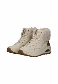 Baskets montantes en simili cuir crème avec un col duveteux, des détails perforés, un design à lacets et une semelle en caoutchouc marron. Amorti d'air transparent.
