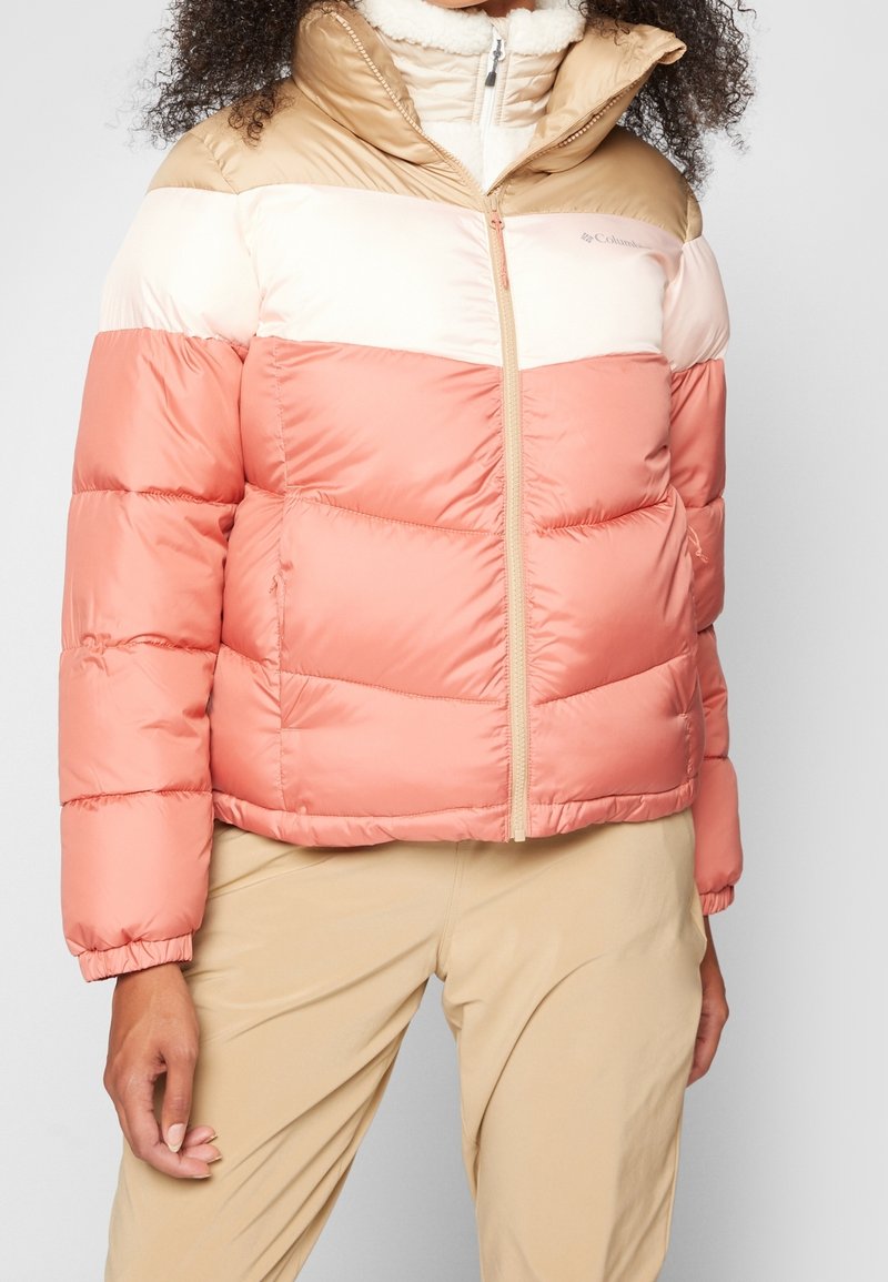 Prošívaná bunda s designem barevných bloků v broskvové, béžové a krémové barvě. Měkká látka a vysoký límec se zapínáním na zip.