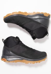 Czarne buty trekkingowe z mixem teksturowanego materiału syntetycznego i siateczki, szary środkowy podeszwa oraz solidna podeszwa z gumy o wyraźnych wypustkach.