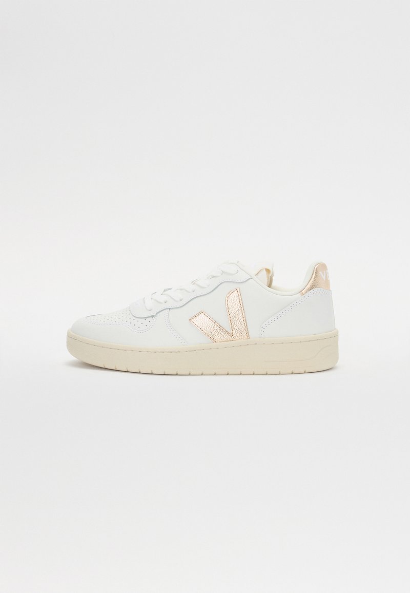 Bijele niske tenisice s perforiranim uzorkom, s metalik ružičastim zlatnim detaljima s bočne i stražnje strane. Gumeni potplat.