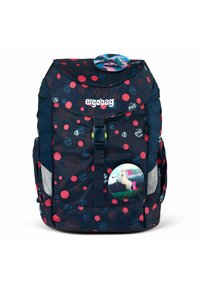 Marineblaues Rucksack mit einem roten und blauen gepunkteten Muster. Verfügt über einen vorderen Schnallenverschluss, seitliche Taschen und ein rundes Einhorn-Abzeichen auf der Vorderseite.